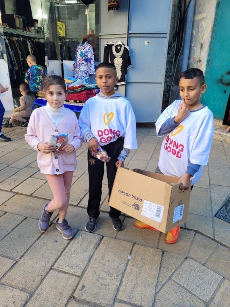 أطفال نادي عبود يجهزون هدايا ويوزعونها على السكان في عكا القديمة في يوم الأعمال الخيرية.