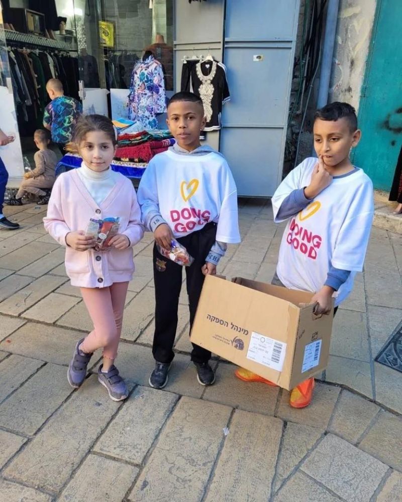 أطفال نادي عبود يجهزون هدايا ويوزعونها على السكان في عكا القديمة في يوم الأعمال الخيرية.